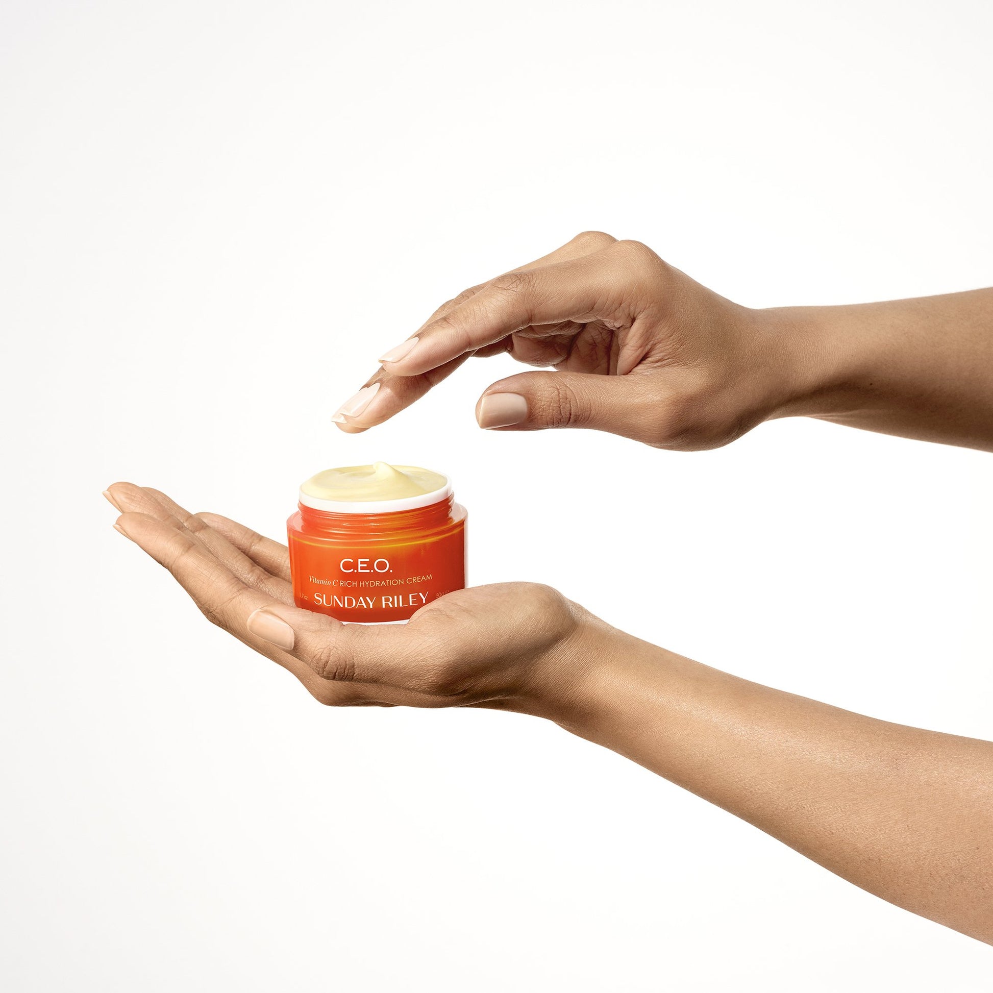 Hands holding open jar of CEO moisturizer